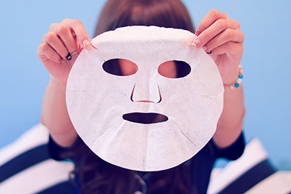 フェイスマスクを持つ女性