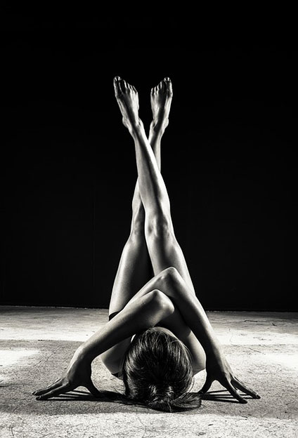 仰向けの姿勢で両脚を上げ、ふくらはぎの位置でクロスしている女性